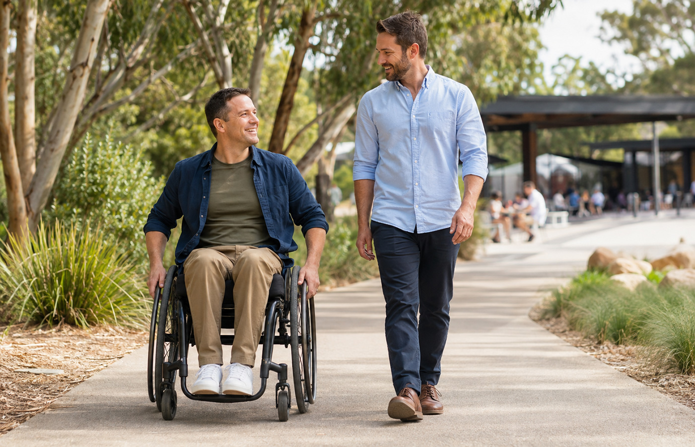An adult wheelchair user and support worker enjoying an accessible Melbourne community park
