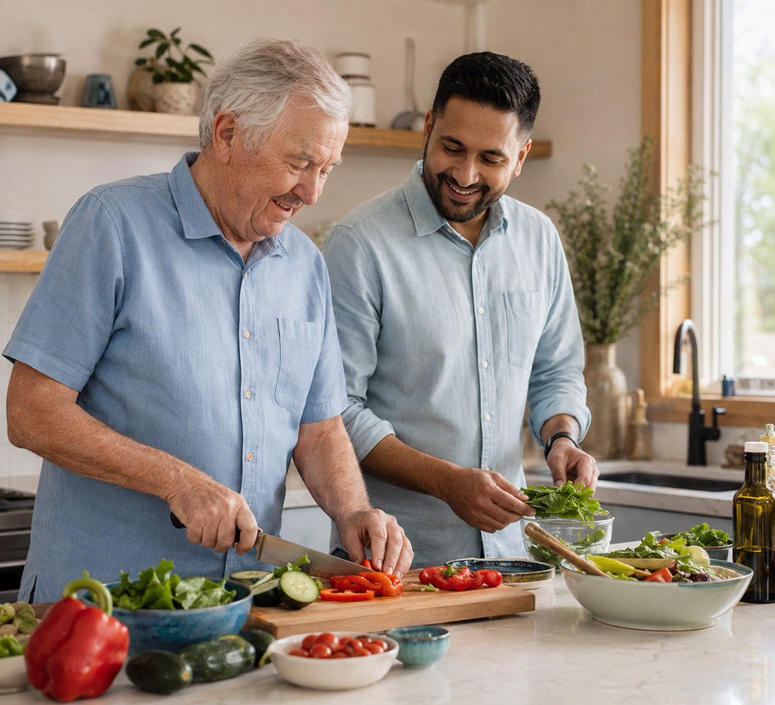 An older person preparing a meal with respectful assistance from a support worker
