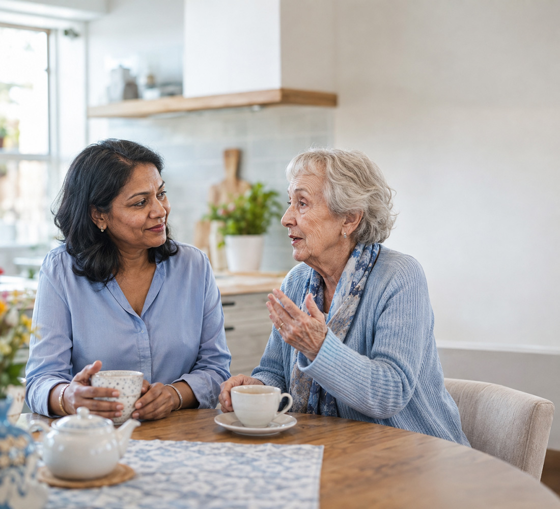 A support professional sharing a relaxed conversation with an older person at home