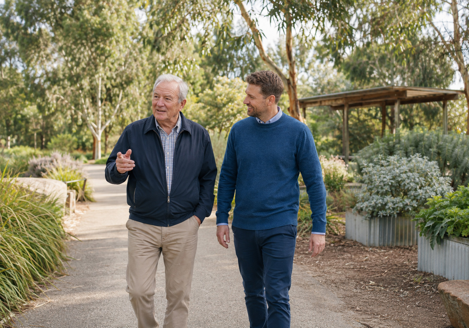Older man enjoying a walk through a Melbourne park with a home-care support worker